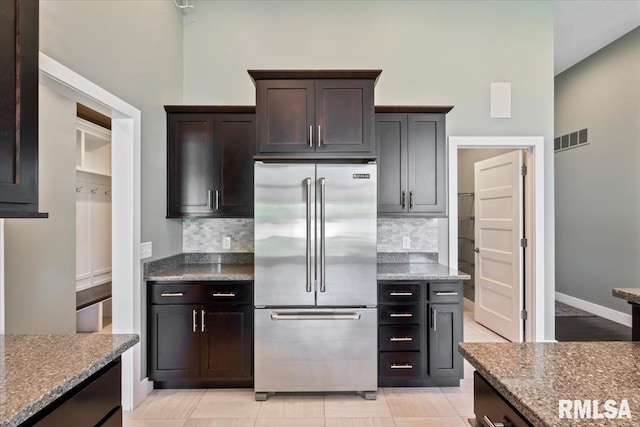 6691 Spring Creek Dr, Bettendorf, IA 52722 - kitchen with high end fridge, backsplash, stone counters, and dark brown cabinetry