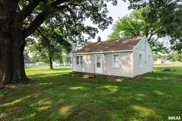 105 Laurel St, Stonefort, IL 62987 - back of property featuring a lawn, a chimney, and a shingled roof