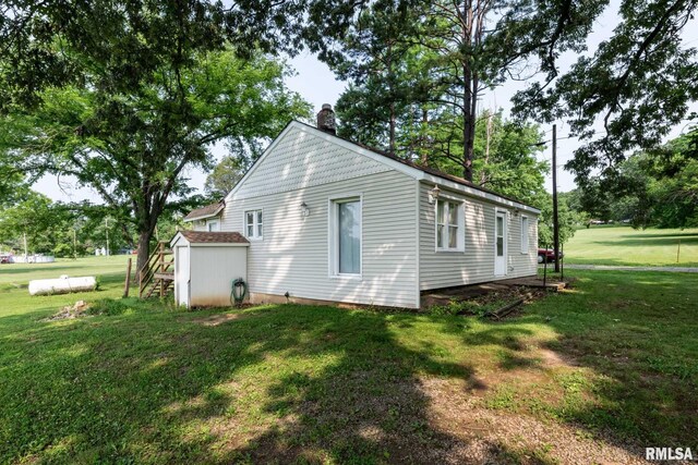 105 Laurel St, Stonefort, IL 62987 - view of side of home featuring a chimney, a storage shed, and a yard