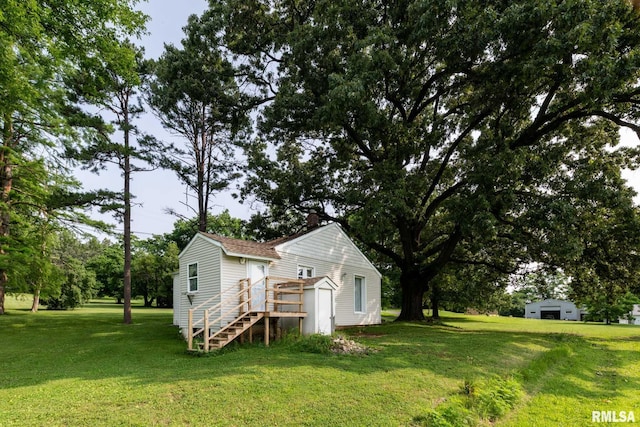 105 Laurel St, Stonefort, IL 62987 - view of home's exterior with a lawn, stairway, a chimney, and an outbuilding