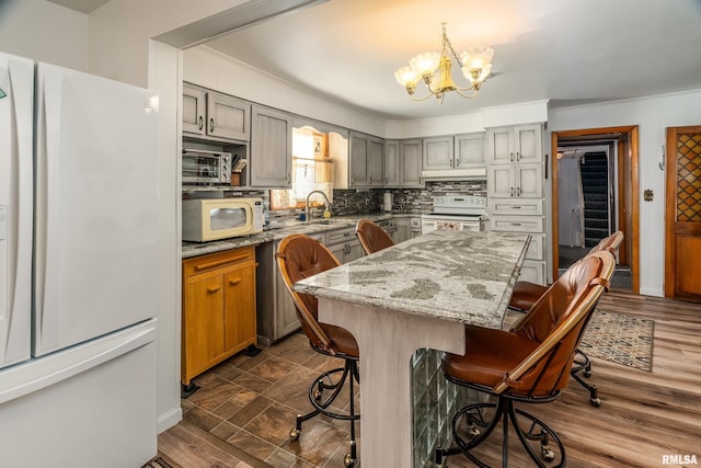 2305 Weaver Rd, Herrin, IL 62948 - kitchen featuring white appliances, a chandelier, a breakfast bar area, a center island, and tasteful backsplash