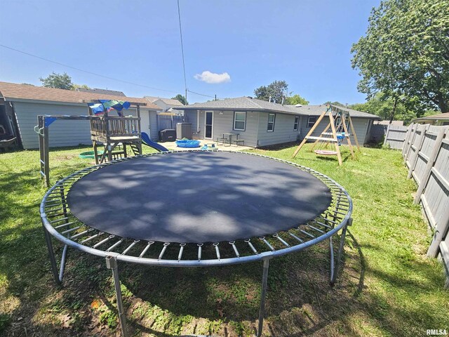 2409 9th St, Silvis, IL 61282 - fenced backyard with a trampoline and a playground