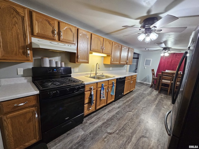 2409 9th St, Silvis, IL 61282 - kitchen featuring black appliances, under cabinet range hood, a ceiling fan, dark wood-style flooring, and light countertops