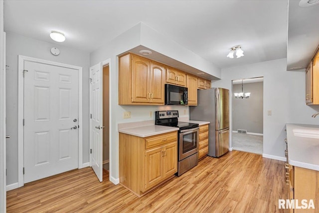 5315 34th Ave, Moline, IL 61265 - kitchen featuring appliances with stainless steel finishes, light wood finished floors, a chandelier, and light countertops
