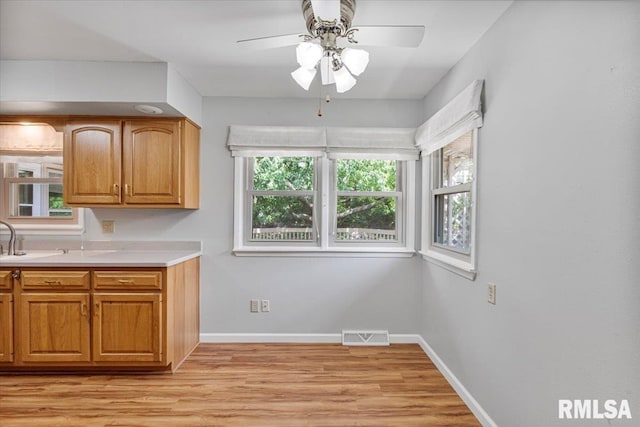 5315 34th Ave, Moline, IL 61265 - kitchen featuring light wood finished floors, ceiling fan, light countertops, and brown cabinets