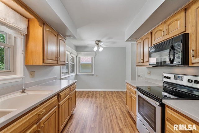 5315 34th Ave, Moline, IL 61265 - kitchen with stainless steel range with electric stovetop, black microwave, ceiling fan, light wood-type flooring, and light countertops