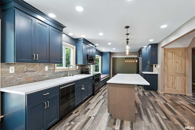 4345 Amesbury Dr, Bettendorf, IA 52722 - kitchen with appliances with stainless steel finishes, a kitchen island, dark wood-style flooring, backsplash, and light countertops