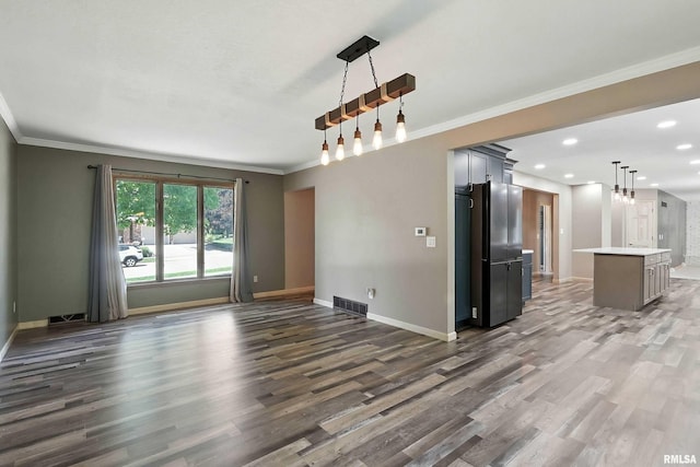 4345 Amesbury Dr, Bettendorf, IA 52722 - unfurnished living room featuring wood finished floors, ornamental molding, and recessed lighting