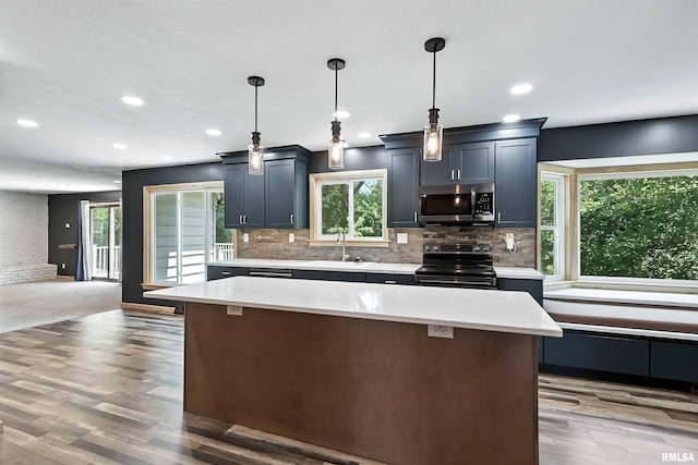 4345 Amesbury Dr, Bettendorf, IA 52722 - kitchen featuring stainless steel microwave, black range with electric cooktop, light countertops, light wood-style floors, and recessed lighting