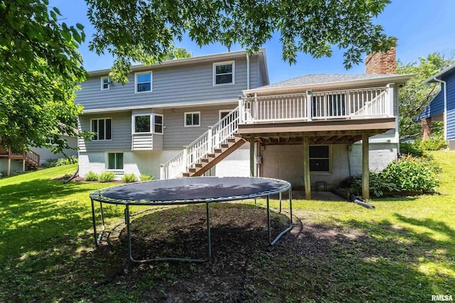 4345 Amesbury Dr, Bettendorf, IA 52722 - back of house featuring a trampoline, stairway, a yard, a chimney, and a wooden deck