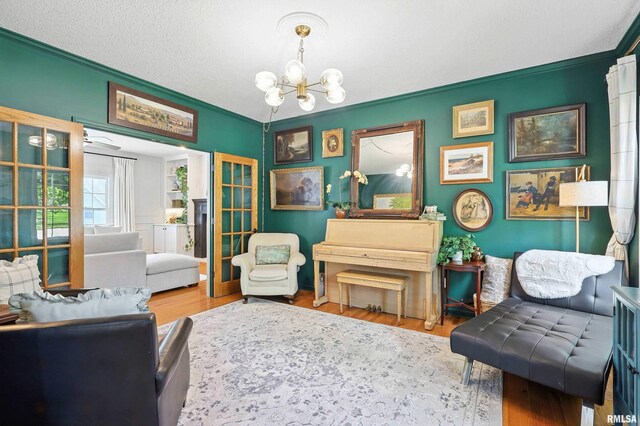 1200 Bridgeview Place, Le Claire, IA 52753 - living area with a chandelier, crown molding, wood finished floors, and a textured ceiling