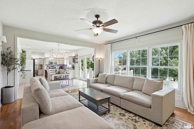 1200 Bridgeview Place, Le Claire, IA 52753 - living room featuring a ceiling fan, a textured ceiling, and light wood-style floors