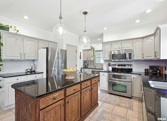 1200 Bridgeview Place, Le Claire, IA 52753 - kitchen with appliances with stainless steel finishes, decorative backsplash, light tile patterned flooring, decorative light fixtures, and a center island