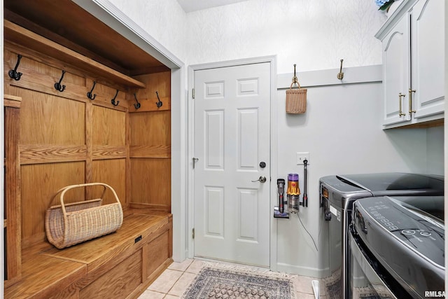 1200 Bridgeview Place, Le Claire, IA 52753 - washroom featuring washing machine and dryer, cabinet space, and light tile patterned floors