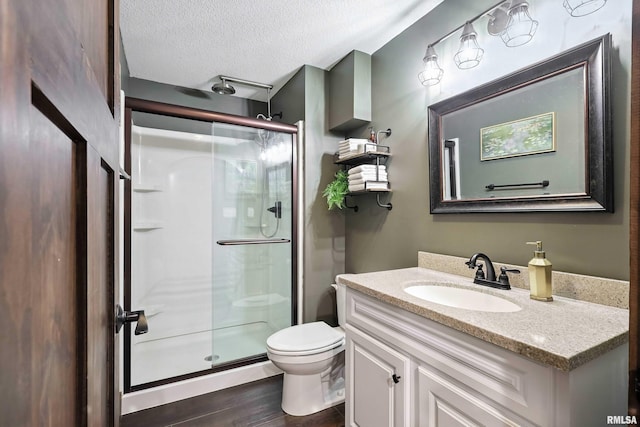 1200 Bridgeview Place, Le Claire, IA 52753 - bathroom featuring a stall shower, vanity, a textured ceiling, and wood finished floors