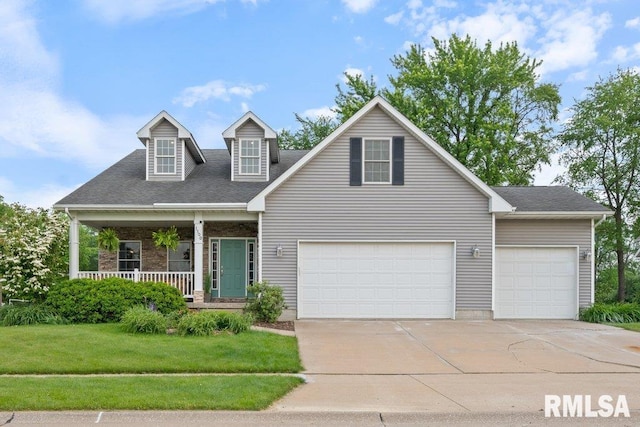 1100 Wild W Dr, Le Claire, IA 52753 - view of front facade with concrete driveway, a front yard, covered porch, a garage, and roof with shingles