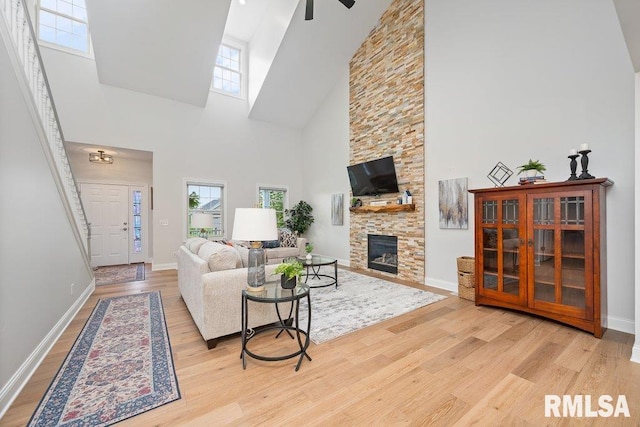 1100 Wild W Dr, Le Claire, IA 52753 - living area featuring a high ceiling, wood finished floors, a stone fireplace, and a ceiling fan
