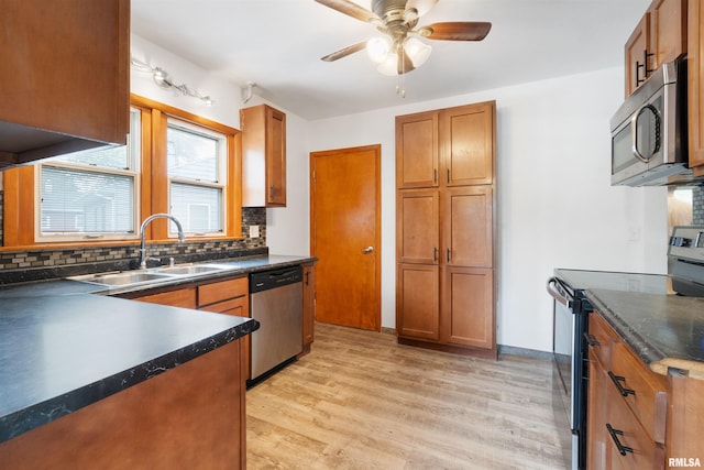 612 Waverly Rd, Davenport, IA 52804 - kitchen featuring appliances with stainless steel finishes, dark countertops, backsplash, a ceiling fan, and light wood-style flooring