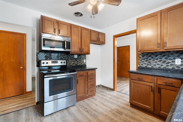 612 Waverly Rd, Davenport, IA 52804 - kitchen with appliances with stainless steel finishes, brown cabinetry, light wood-style floors, a ceiling fan, and tasteful backsplash