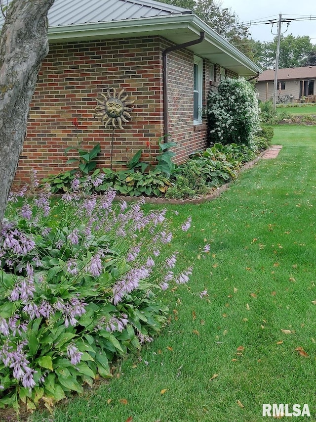 206 E 13th St, Tipton, IA 52772 - view of side of property with brick siding, a lawn, and a standing seam roof