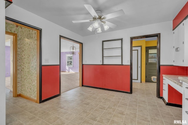 206 E 13th St, Tipton, IA 52772 - empty room featuring a wainscoted wall and ceiling fan