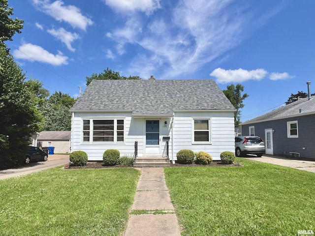 1130 53rd St, Moline, IL 61265 - view of front of home featuring a front yard, roof with shingles, and a chimney