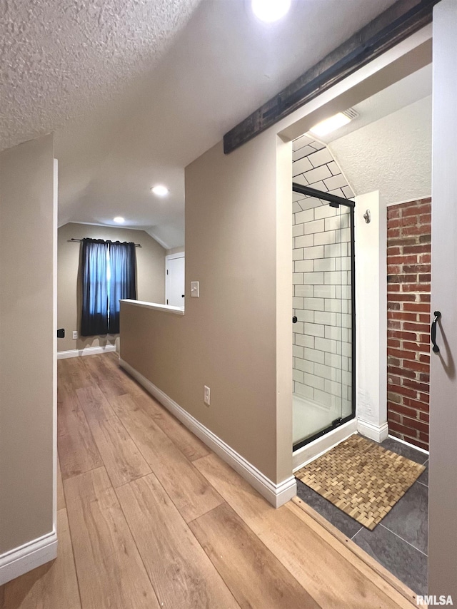 1130 53rd St, Moline, IL 61265 - bathroom featuring a shower stall, wood finished floors, a textured ceiling, and vaulted ceiling