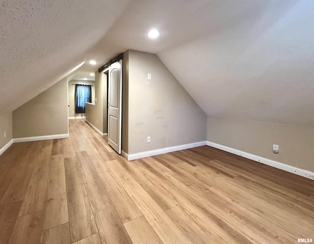 1130 53rd St, Moline, IL 61265 - additional living space featuring light wood-type flooring, a textured ceiling, vaulted ceiling, and recessed lighting