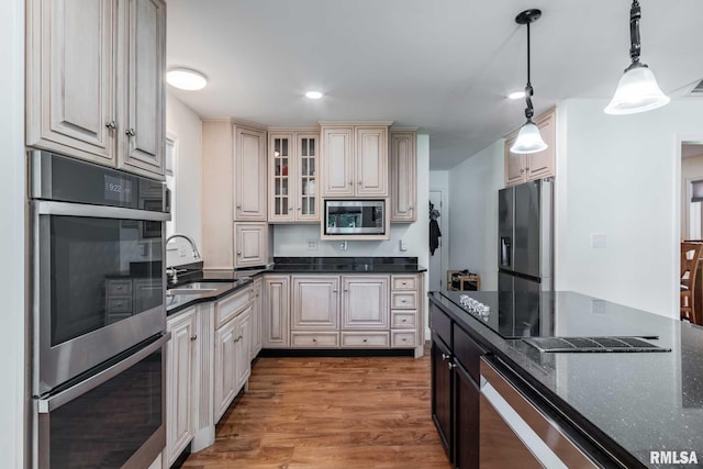 901 E Gregory Ave, Marion, IL 62959 - kitchen with appliances with stainless steel finishes, pendant lighting, light wood-type flooring, dark stone countertops, and glass insert cabinets
