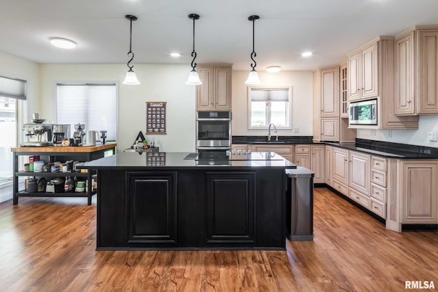 901 E Gregory Ave, Marion, IL 62959 - kitchen featuring stainless steel microwave, cream cabinetry, dark countertops, a kitchen island, and wood finished floors