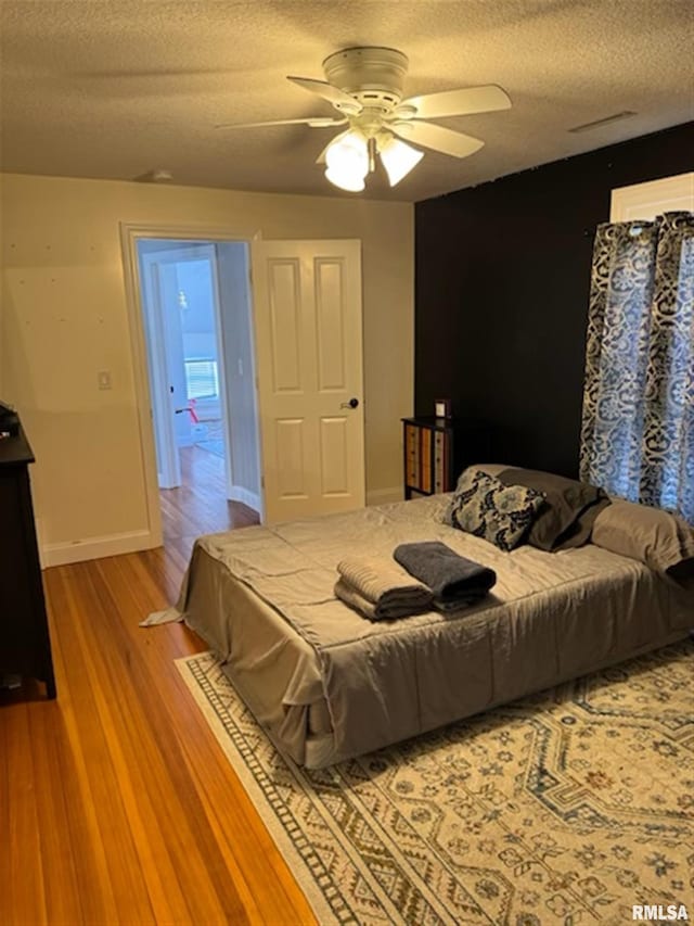 3119 15th St Unit C, Moline, IL 61265 - bedroom featuring a textured ceiling, wood finished floors, and ceiling fan