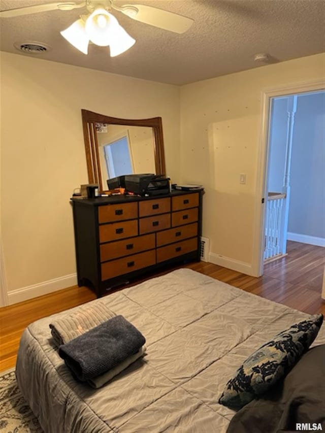 3119 15th St Unit C, Moline, IL 61265 - bedroom with wood finished floors, a textured ceiling, and ceiling fan