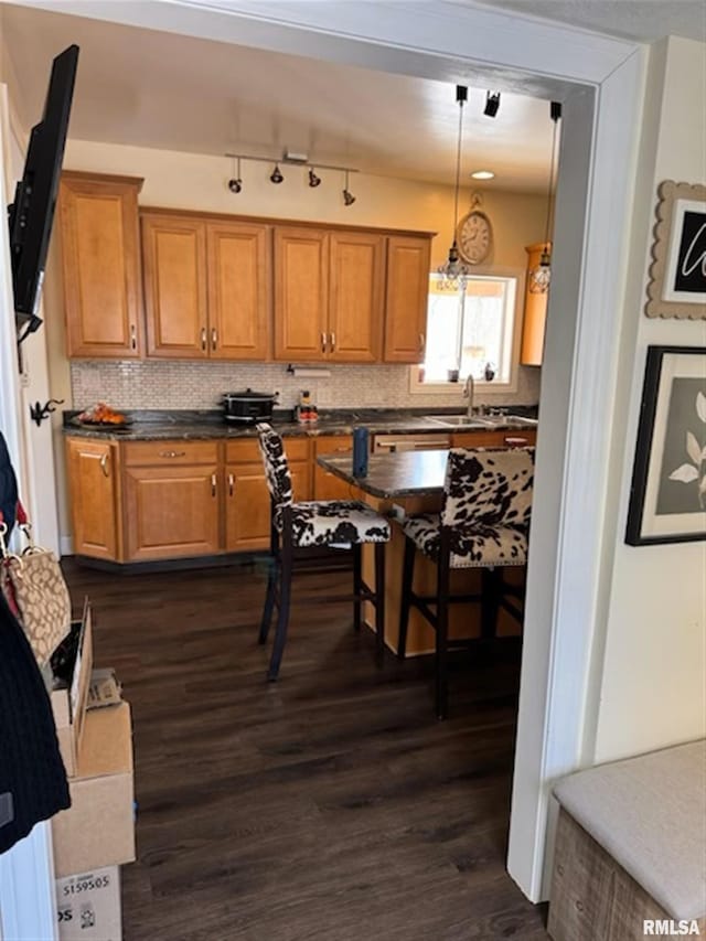 3119 15th St Unit C, Moline, IL 61265 - kitchen with brown cabinetry, backsplash, dark wood finished floors, dark countertops, and pendant lighting