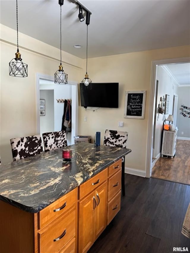 3119 15th St Unit C, Moline, IL 61265 - kitchen featuring brown cabinetry, pendant lighting, dark wood-style flooring, crown molding, and dark stone counters