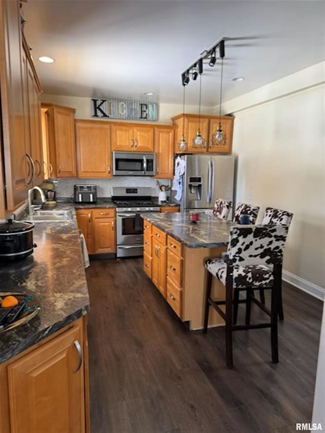 3119 15th St Unit C, Moline, IL 61265 - kitchen featuring stainless steel appliances, dark wood-style flooring, a center island, pendant lighting, and brown cabinets