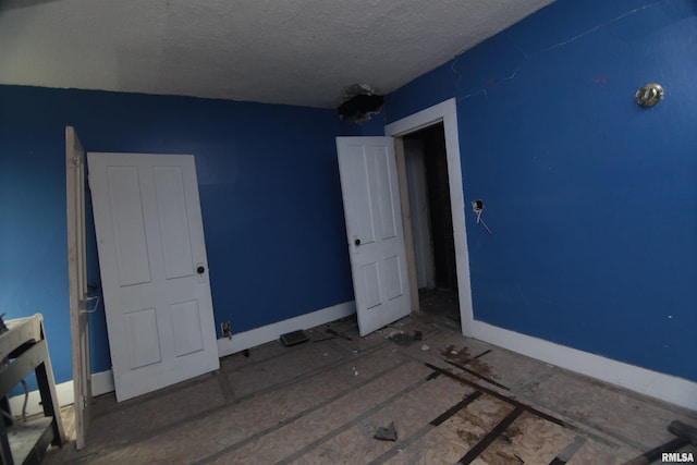 1116 Arlington Ave, Davenport, IA 52803 - unfurnished bedroom with a textured ceiling and baseboards