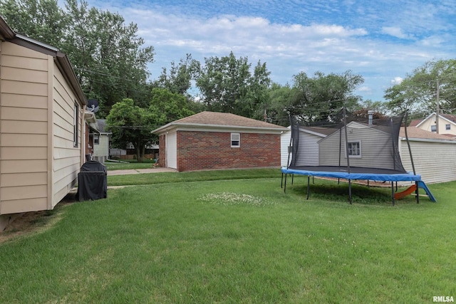 419 50th St, Moline, IL 61265 - view of green lawn with a trampoline, an outdoor structure, and a garage