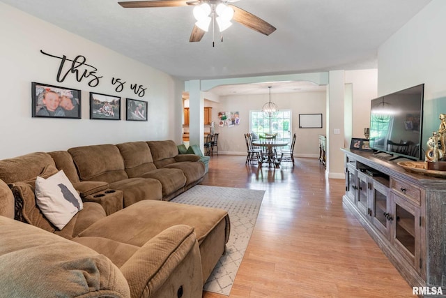 4182 Baptist Camp Rd, Carterville, IL 62918 - living room with a ceiling fan, arched walkways, light wood finished floors, and a chandelier
