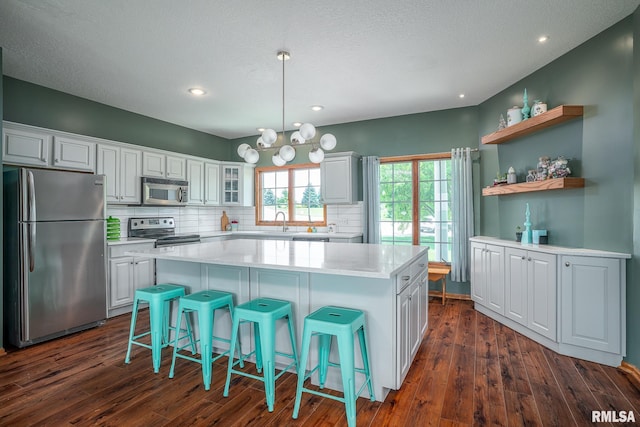 27062 238th St, Le Claire, IA 52753 - kitchen featuring stainless steel appliances, backsplash, dark wood-style floors, a kitchen island, and recessed lighting