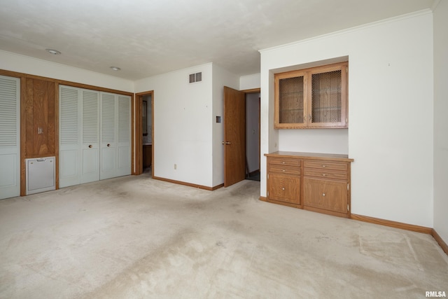 1427 35th Ave, Rock Island, IL 61201 - unfurnished bedroom featuring ornamental molding, light carpet, and a closet