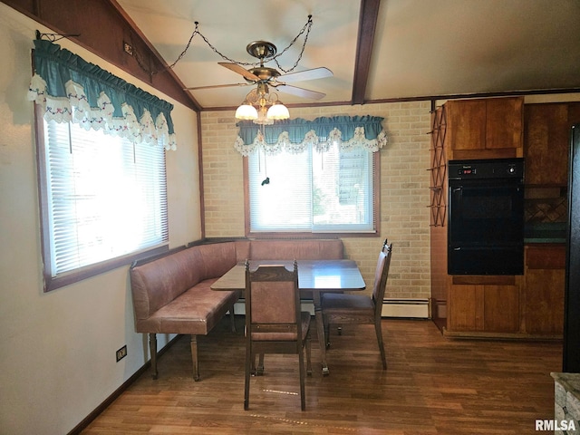 509 W 9th St, Tipton, IA 52772 - dining space with a baseboard heating unit, ceiling fan, wood finished floors, and brick wall