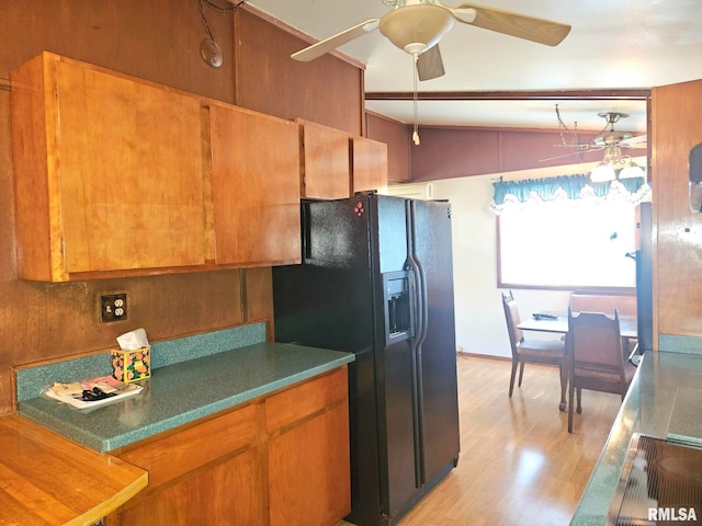 509 W 9th St, Tipton, IA 52772 - kitchen featuring black fridge, light wood finished floors, a ceiling fan, brown cabinetry, and lofted ceiling