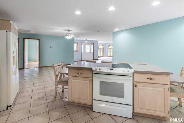 10415 Chayla Rd, Marion, IL 62959 - kitchen featuring white appliances, light brown cabinets, light countertops, a kitchen breakfast bar, and recessed lighting