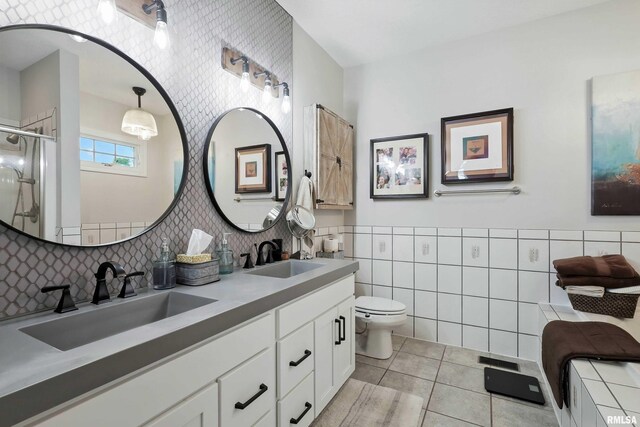 21945 Great River Rd, Le Claire, IA 52753 - bathroom featuring tile walls, tile patterned flooring, double vanity, and an enclosed shower