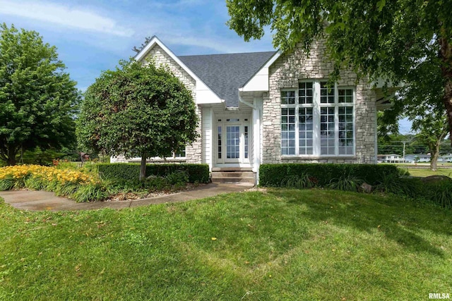 21945 Great River Rd, Le Claire, IA 52753 - view of front of home with stone siding, a front yard, and a shingled roof