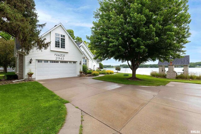 21945 Great River Rd, Le Claire, IA 52753 - view of side of property featuring concrete driveway, a water view, a yard, and a garage