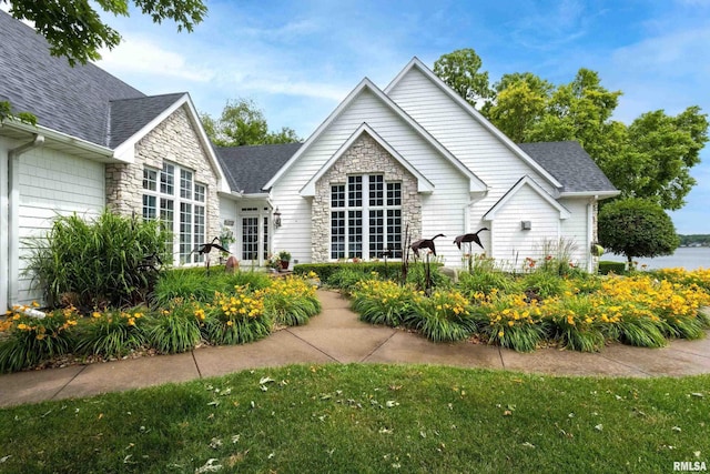 21945 Great River Rd, Le Claire, IA 52753 - rear view of property featuring stone siding, a shingled roof, and a lawn