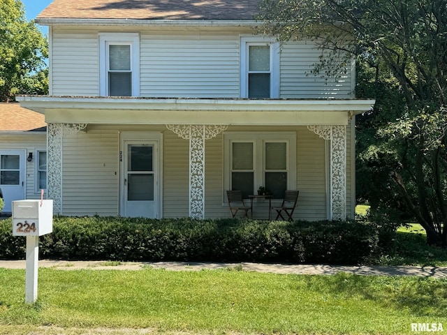 224 S Henderson St, Toulon, IL 61483 - view of front of house with covered porch, a front lawn, and roof with shingles