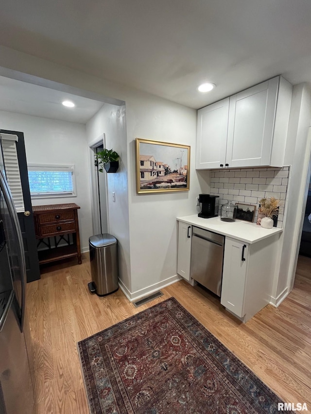 224 S Henderson St, Toulon, IL 61483 - kitchen featuring dishwasher, freestanding refrigerator, light wood-type flooring, white cabinetry, and backsplash