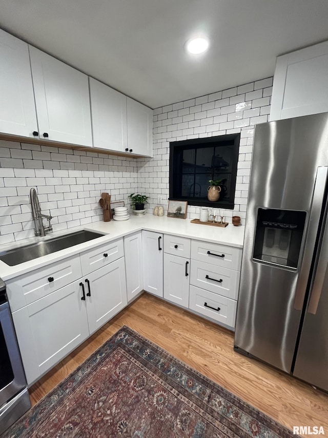 224 S Henderson St, Toulon, IL 61483 - kitchen with stainless steel fridge with ice dispenser, light wood-style flooring, light countertops, and white cabinetry